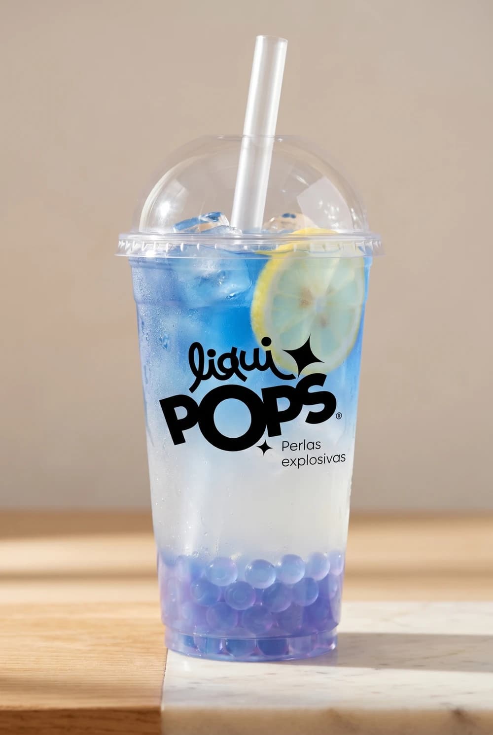 Limonada azul de flor de mariposa con perlas explosivas LiquiPops y rodaja de limón — vaso para llevar