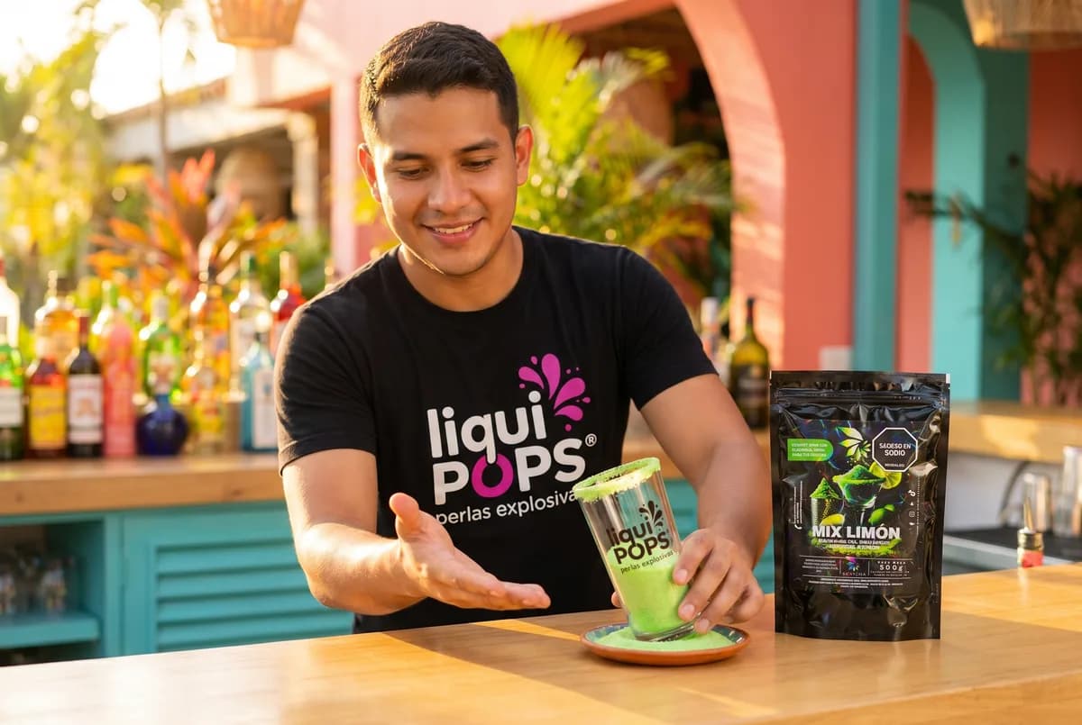 Bartender LiquiPops escarcha un vaso con Mix Limón para michelada en bar tropical — escarcha verde de limón, ambiente costeño