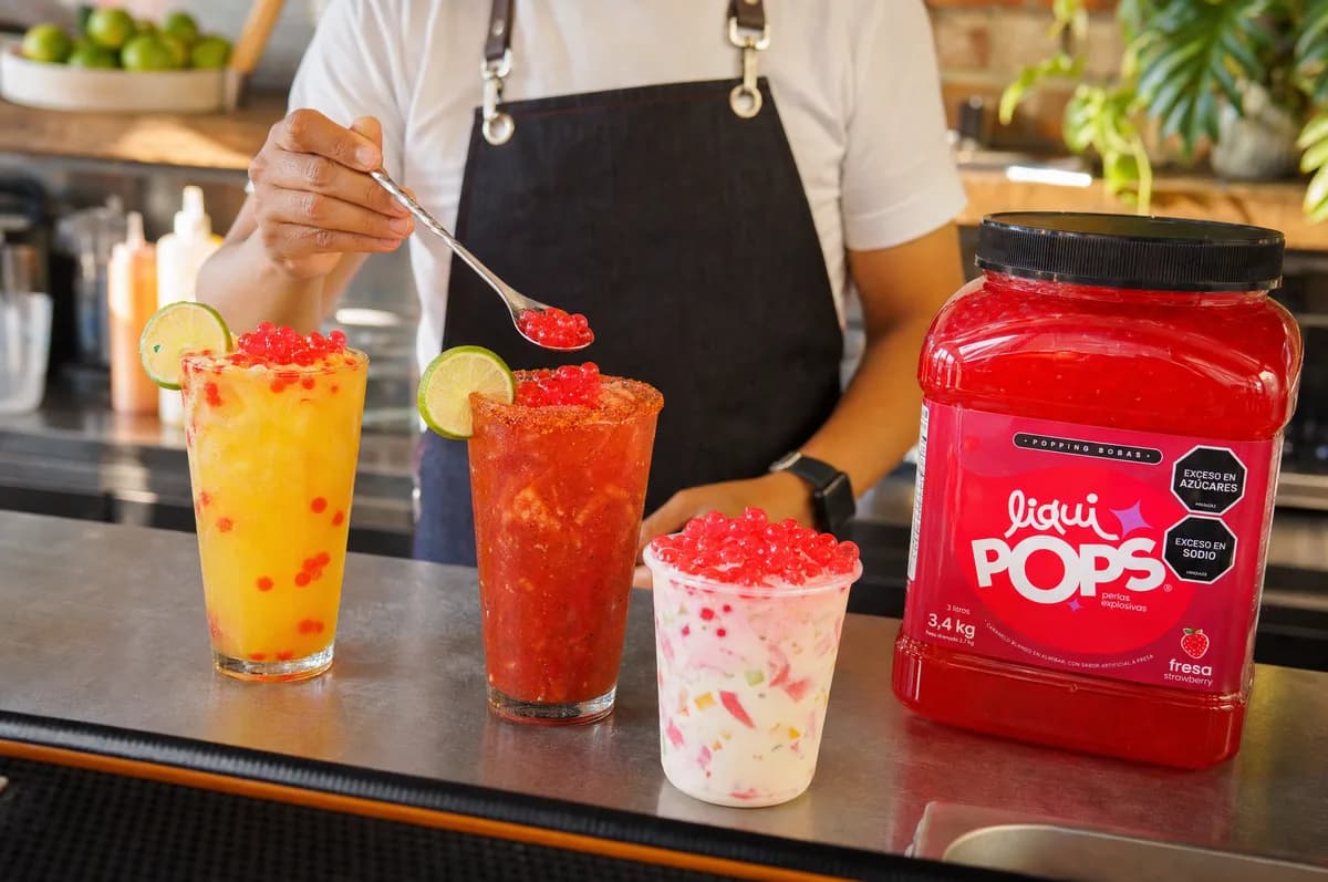 Michelada, soda de mango y cholado con perlas explosivas de fresa LiquiPops junto al balde de producto — barra de bebidas
