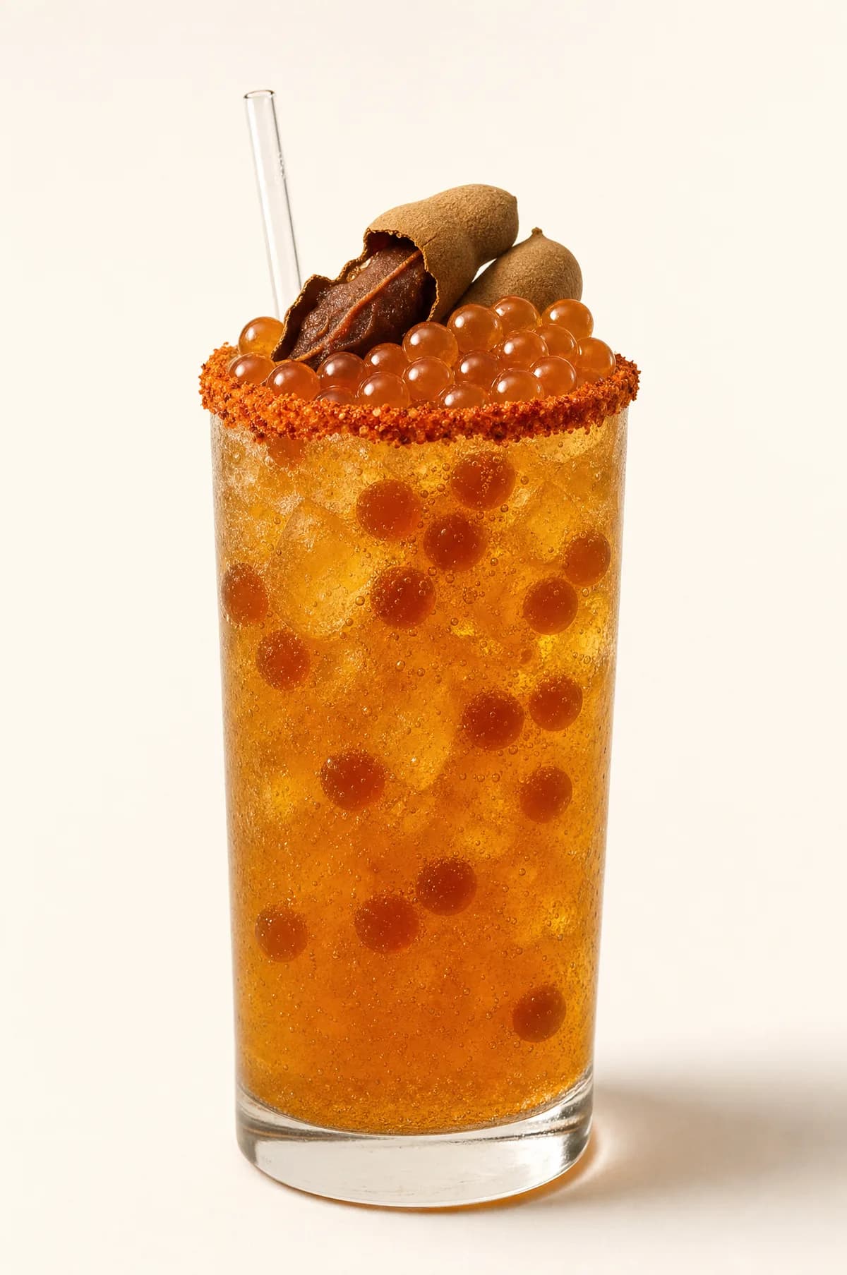 Michelada de tamarindo con perlas explosivas LiquiPops y escarcha en el borde — vaso alto con tamarindo de garnish