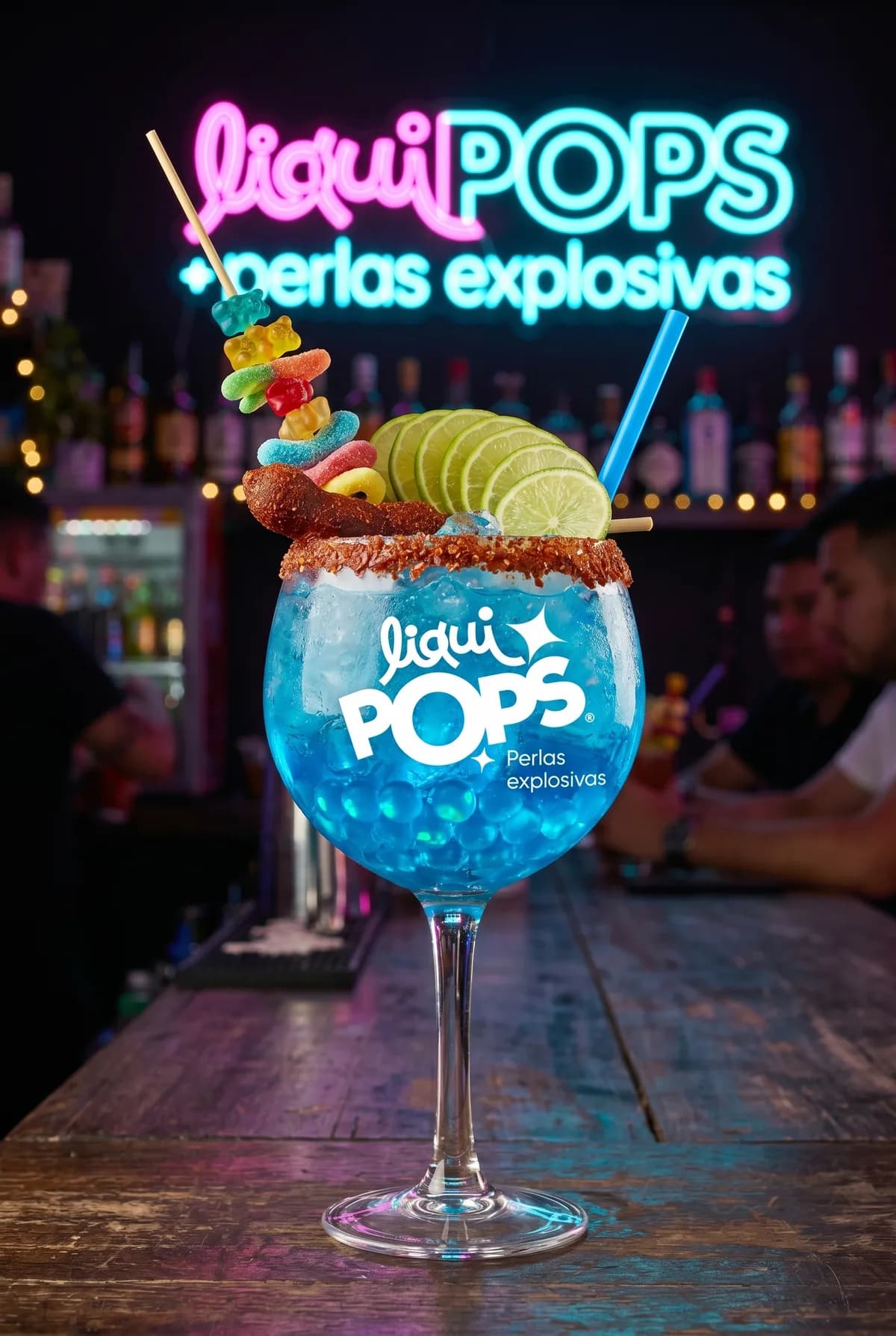 Copa de soda loca azul con perlas explosivas LiquiPops, escarcha de chamoy y gomitas — servida en una barra con neón LiquiPops