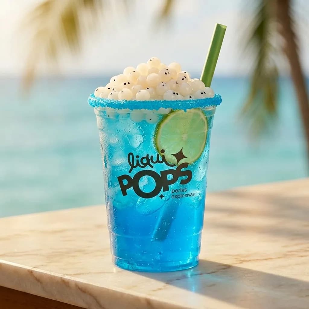 Soda loca azul con perlas explosivas de litchi y limon LiquiPops, escarchado azul frente al mar