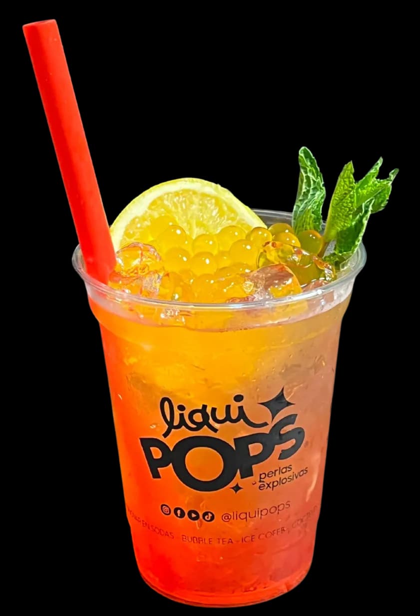 Vaso de bubble tea de leche con perlas explosivas rojas LiquiPops en el fondo — pitillo rojo sobre fondo beige