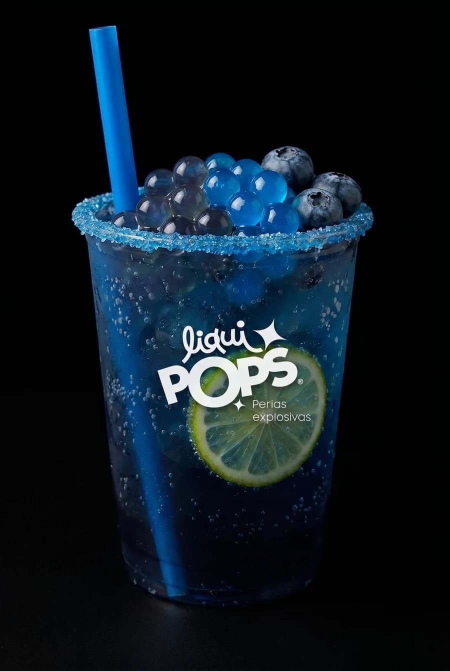 Soda azul de blueberry con perlas explosivas LiquiPops, arándanos y limón en vaso escarchado azul sobre fondo negro