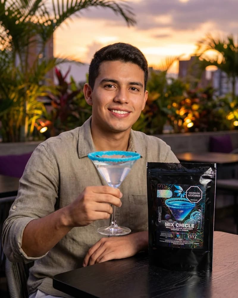 Coctel en copa martini con borde escarchado azul sabor chicle Skarcha y perlas explosivas LiquiPops en una terraza al atardecer