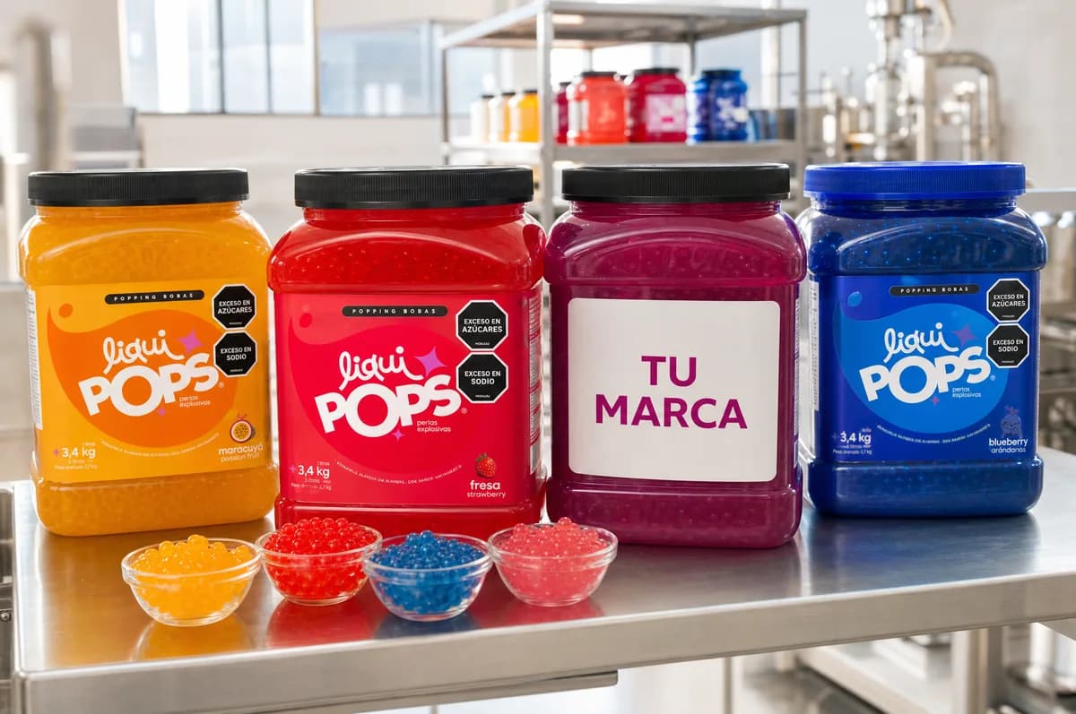 Cuatro tinas de 3,4 kg de maracuyá, fresa, marca propia y blueberry con bowls de perlas explosivas de sabores con perlas explosivas LiquiPops sobre mesa de acero