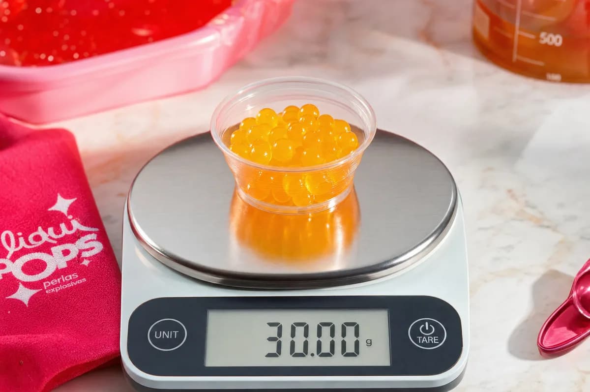 Porción de 30 gramos de perlas explosivas LiquiPops sabor maracuyá sobre una báscula digital — control de porciones