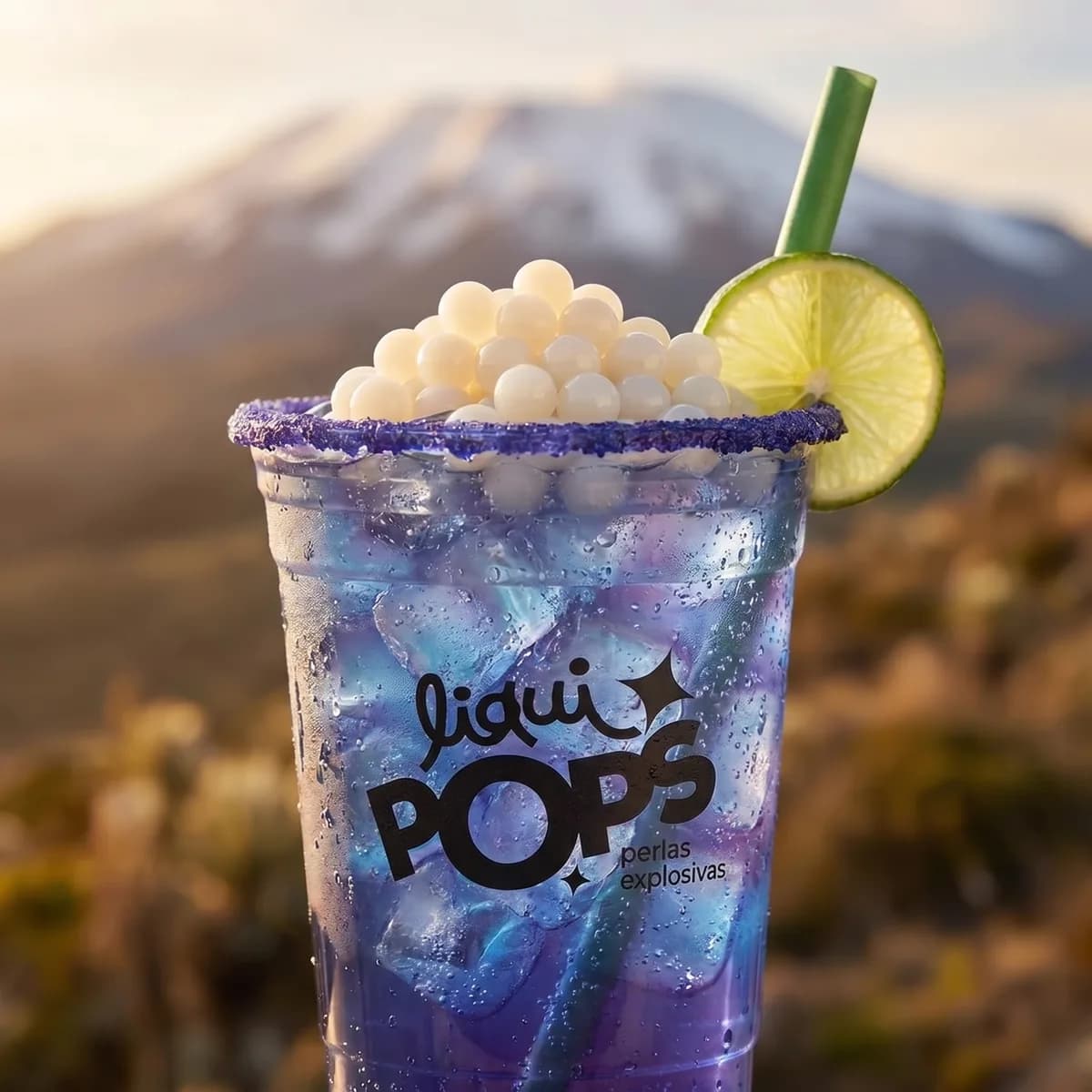 Soda loca degradado galaxia con perlas explosivas LiquiPops sabor lichi, escarcha morada y limon — volcan nevado al fondo