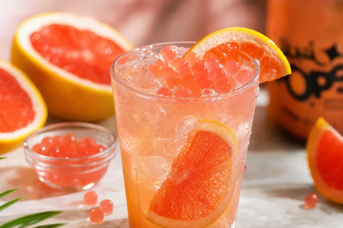 Soda loca de toronja con hielo y perlas explosivas LiquiPops, decorada con rodajas de toronja