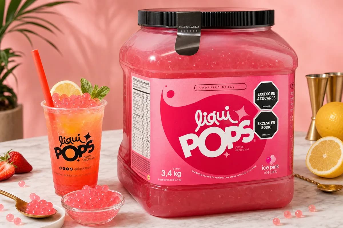 Tarro de perlas explosivas LiquiPops sabor ice pink de 3,4 kg con soda rosada y perlas explosivas LiquiPops en tazon — escena con limon y fresas