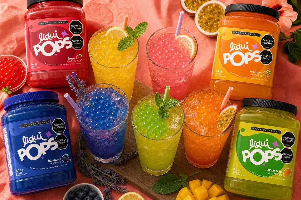 Tarros de perlas explosivas LiquiPops junto a sodas de colores con perlas explosivas — fresa, mango y manzana verde servidas en vaso