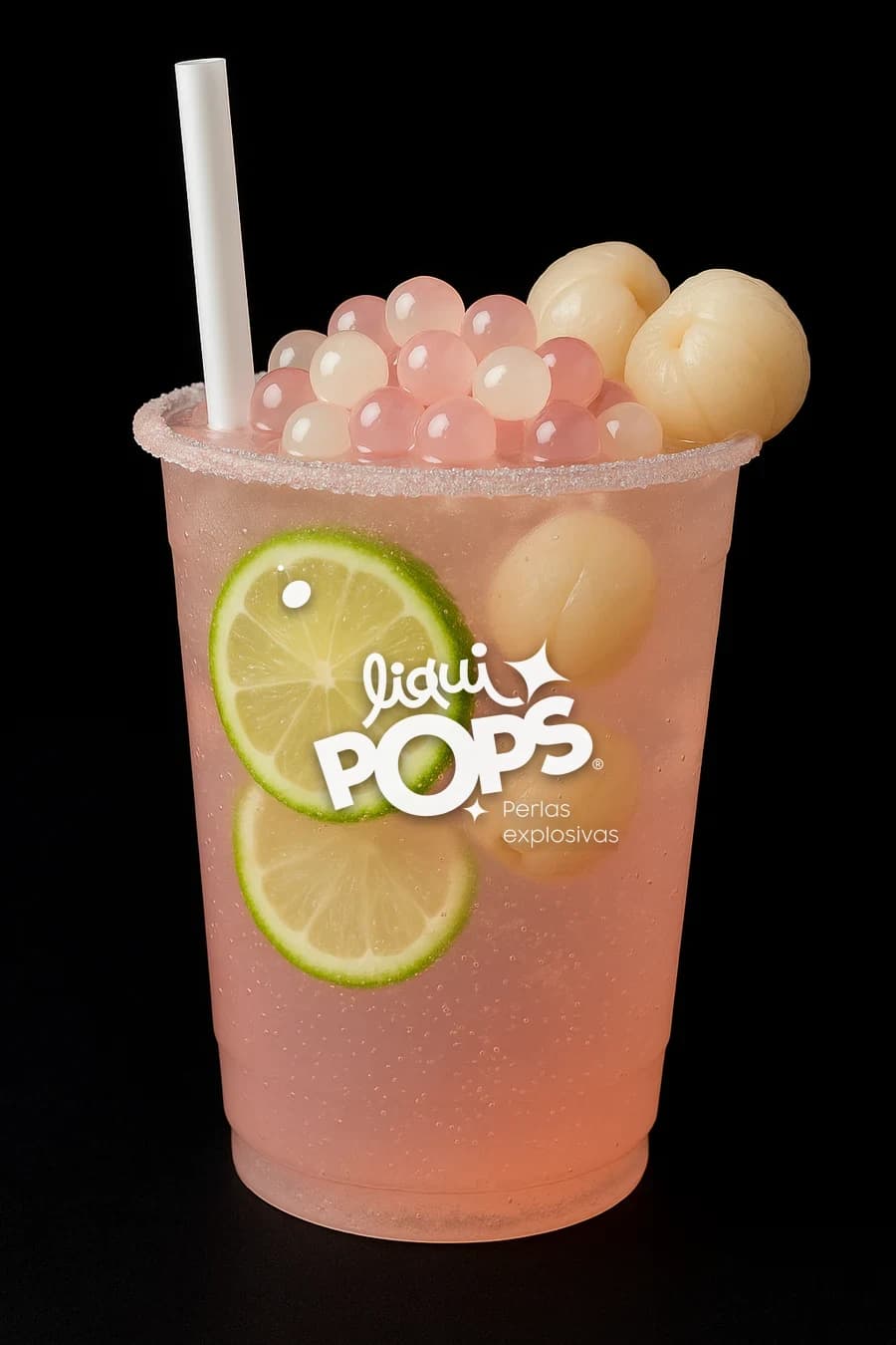 Soda de lychee rosada con perlas explosivas LiquiPops, lychees enteros y rodajas de limon en vaso escarchado