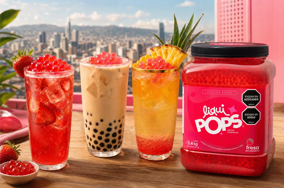 Trío de bebidas con perlas explosivas LiquiPops y bubble tea de bola negra frente a vista de ciudad y bote de fresa