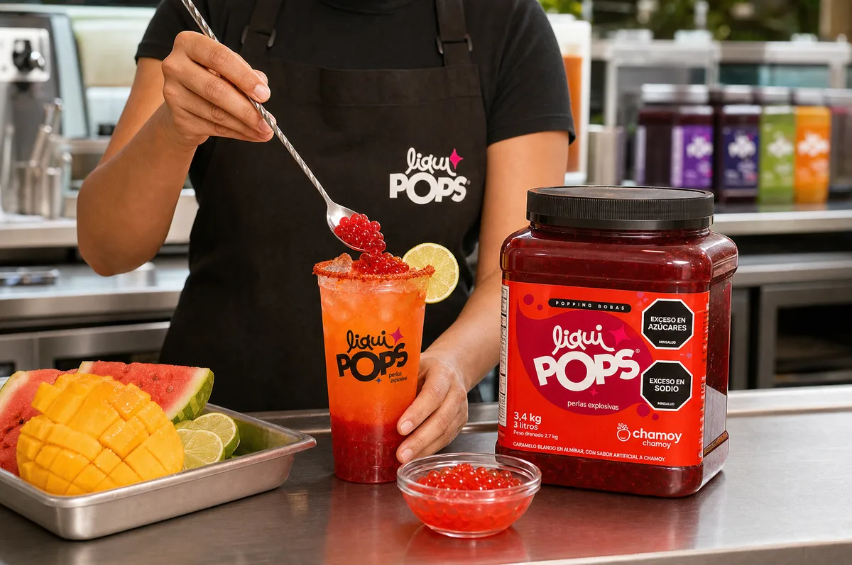 Barista sirviendo perlas explosivas LiquiPops chamoy sobre michelada de frutas junto al bidón de 3,4 kg