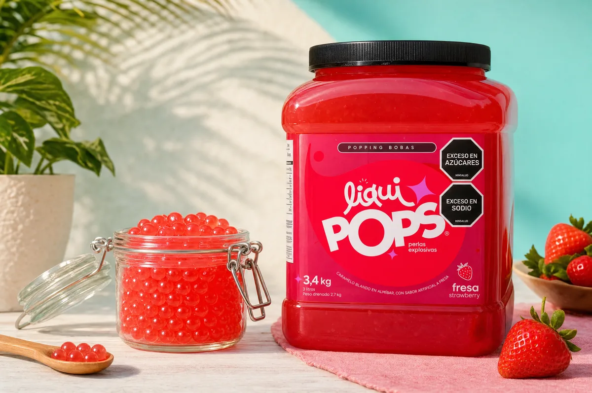 Tarro de perlas explosivas LiquiPops sabor fresa con frasco y cuchara de perlas rojas y fresas frescas