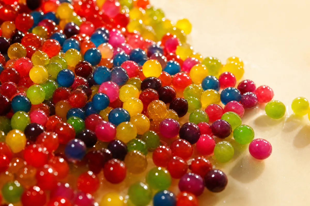 Montón de perlas explosivas LiquiPops de sabores surtidos brillando con la luz — topping para bebidas