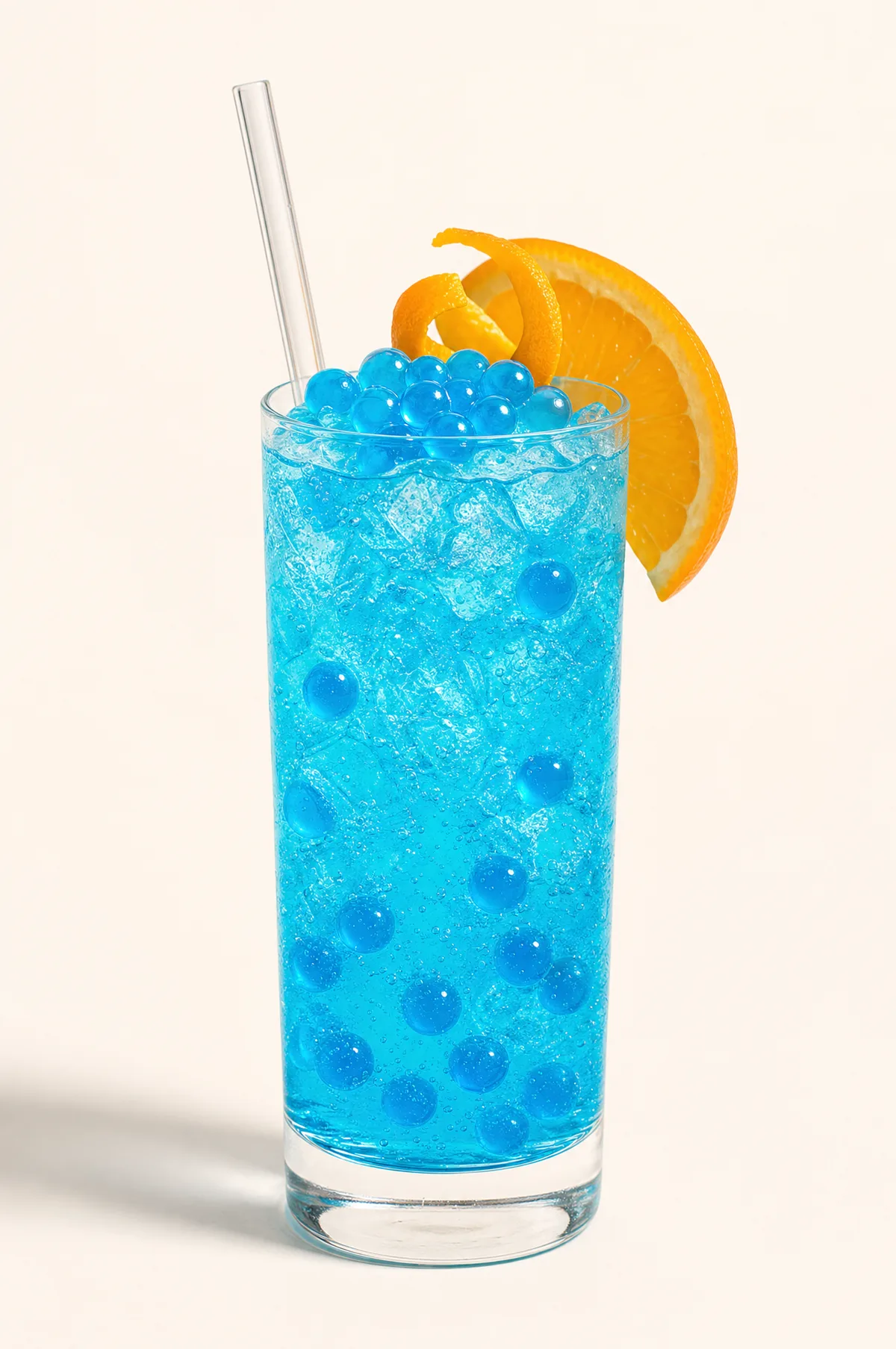 Soda azul con perlas explosivas LiquiPops y hielo — vaso alto con rodaja de naranja