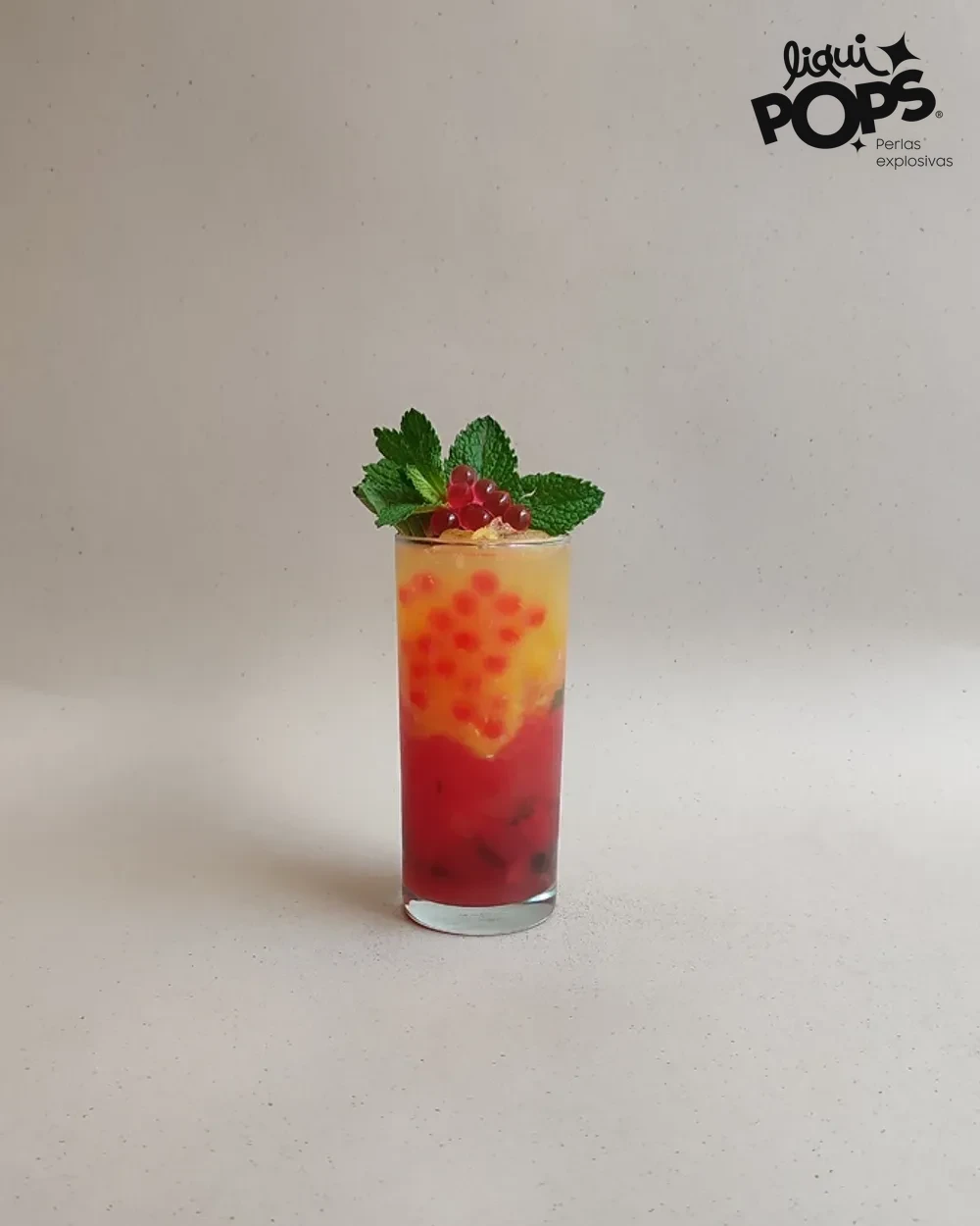 Soda en capas de sandia y naranja con perlas explosivas rojas LiquiPops y grosellas en vaso alto — receta de bebida frutal