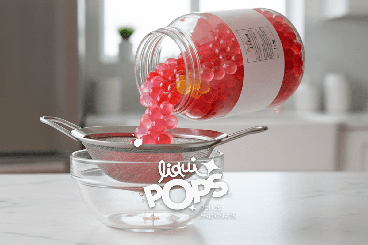 Side-view of a 1150g LiquiPops jar tipped over a stainless steel strainer, multicolor popping boba pearls draining out w.