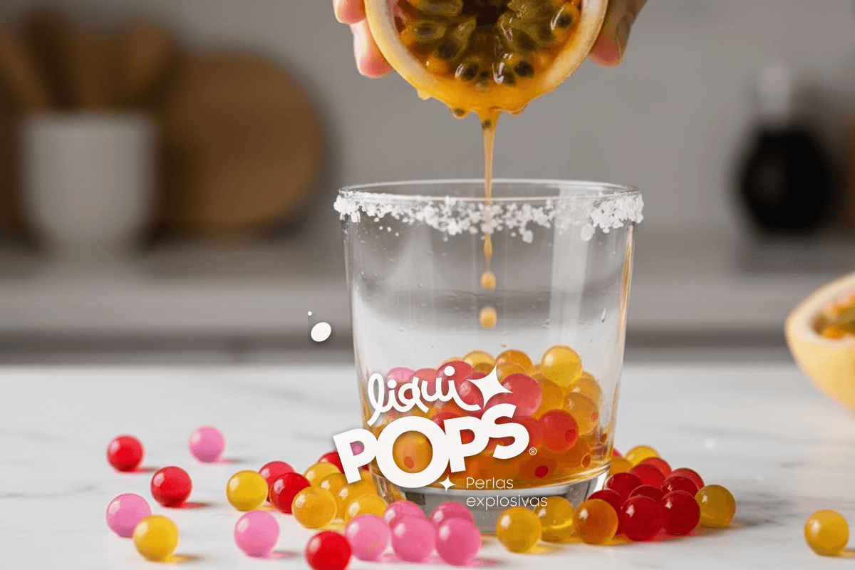 Macro of fresh passion fruit halves being squeezed over a glass, juice and seeds falling, salt rim visible.