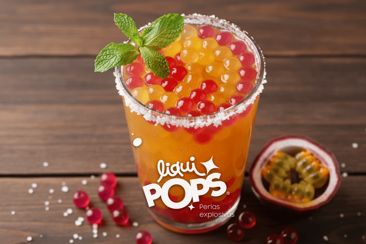 Top-down of finished michelada de maracuyá with mint sprig garnish, salt scattered on the wooden table, half passion fru.