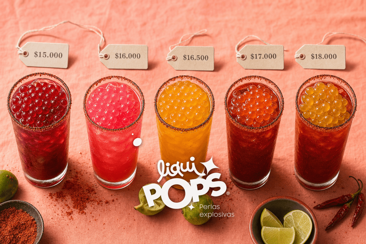 Editorial flatlay overhead: five tall michelada glasses arranged in a row, each topped with popping boba pearls of diffe.